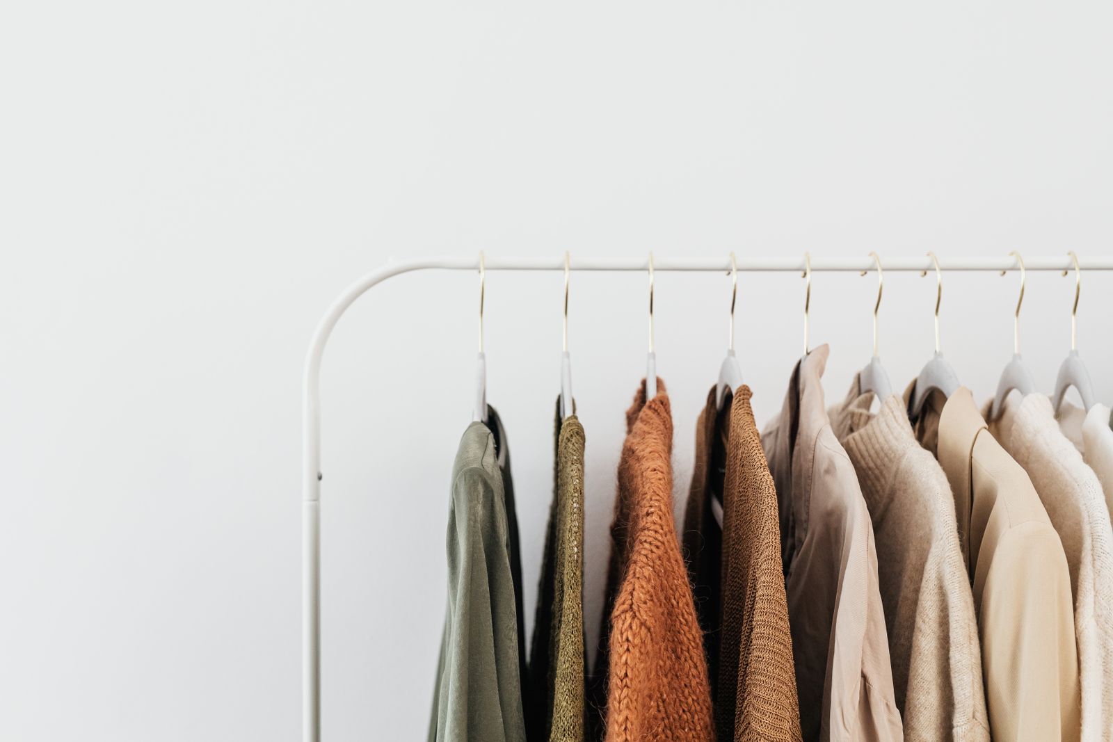 A neutral capsule wardrobe on a rail